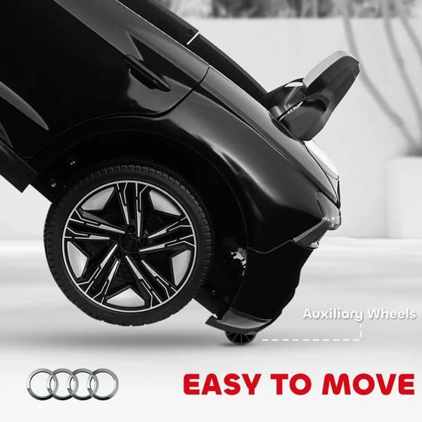 Black kids electric ride-on car front wheel with auxiliary wheels, side view close-up
