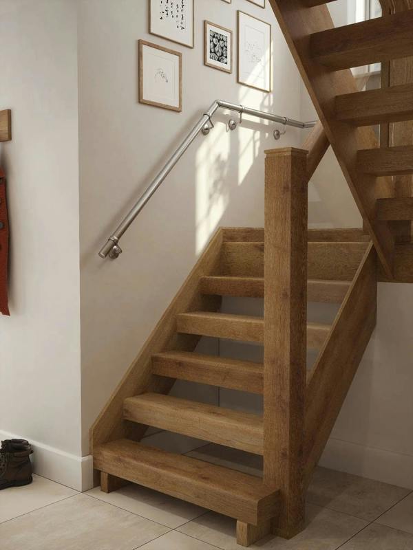 Brushed silver 40mm half turn handrail fitted to staircase wall, angled view