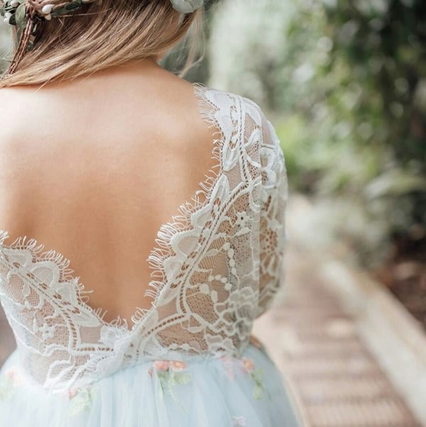 Lace-trimmed dress with floral details in a natural setting