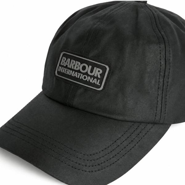 Black Barbour International wax cotton baseball cap with a tonal branded rubber patch on the front.