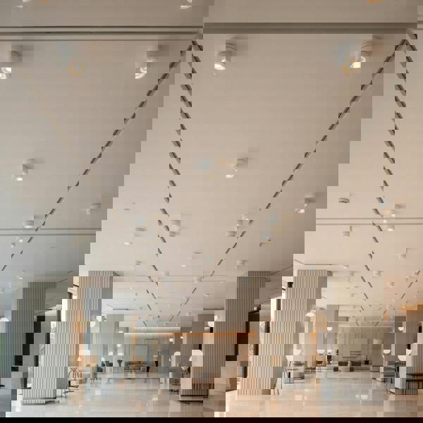 white adjustable ceiling light mounted on a high ceiling in a hotel 