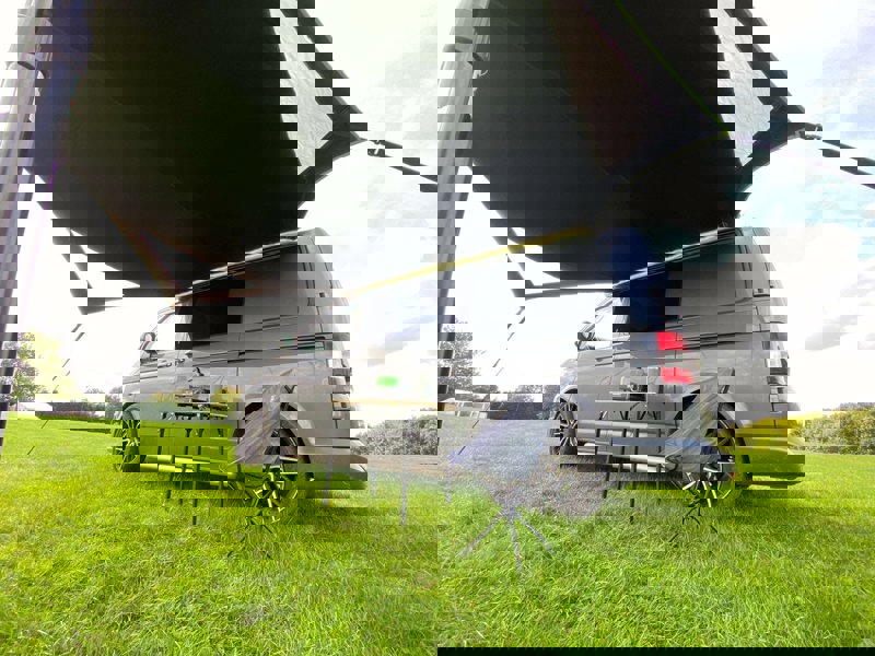 Image of Modern Shade Canopy grey with  Lime by OLPRO fitted on T5 Campervan, picture from low down right side showing the underside and space available under the canopy.