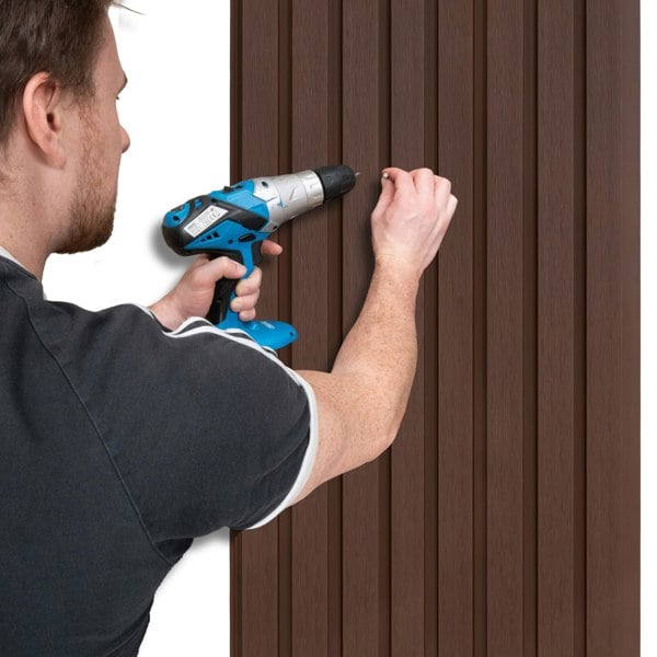 WPC slatted wall cladding panels in rich brown, being installed with a power drill, showcasing their textured finish and sleek design