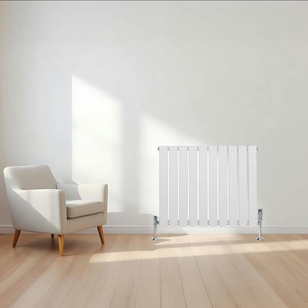 Flat single column radiator in white, 600 x 700mm, featuring sleek vertical lines, positioned beside a modern armchair in a bright room