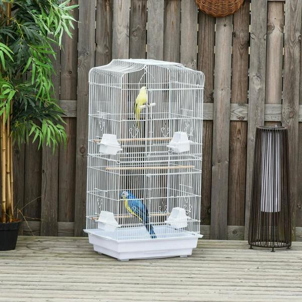 White metal bird cage with perches and feeding cups, with birds inside