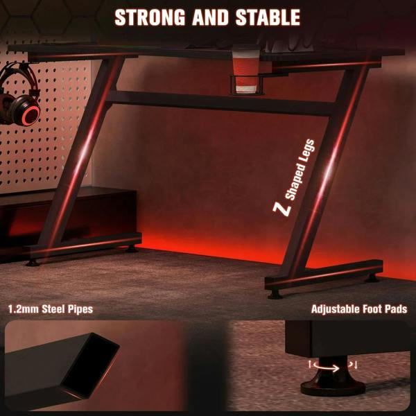 Black gaming desk with steel legs and adjustable foot pads for stable leveling