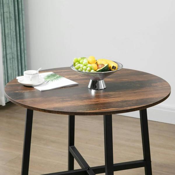 Round dining table with rustic brown top and black steel legs, styled with serving tray