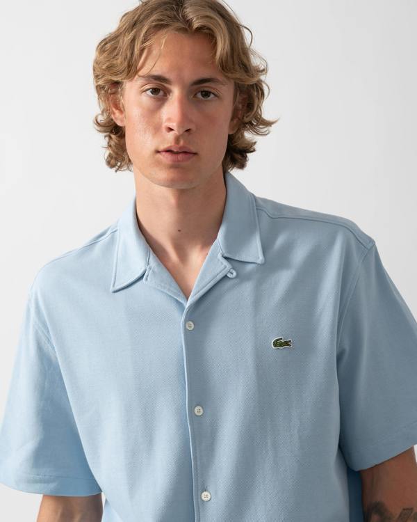 close up shot of a model wearing a Lacoste Relaxed Fit Short Sleeved Mens Piqué Shirt in Chambray HBA