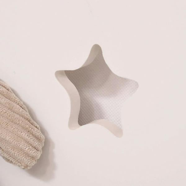 Star-shaped decorative cutout on the white back panel of a pink kids toy box.