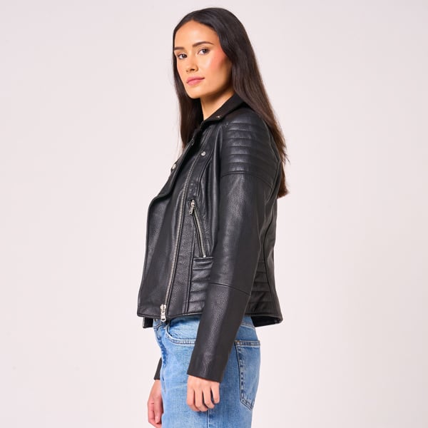 Model faces to the side to show the ribbed sleeve and waist detail of the Barneys Originals Victoria biker jacket. 