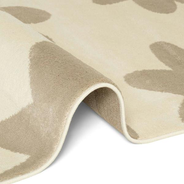 Close-up of a beige and brown patterned rug corner on a white background