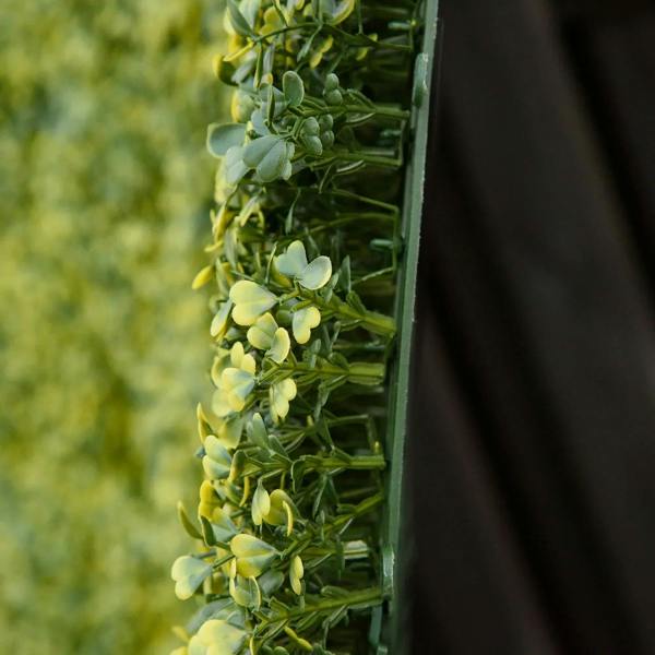 Artificial faux hedge panel edge view with dense bright green leaves