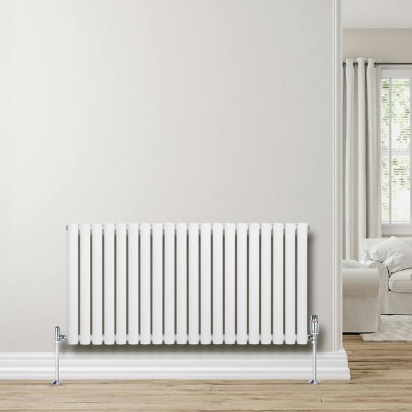 Sleek white oval single column radiator, 600 x 1200mm, mounted on a light wall, complementing a modern interior with wooden flooring