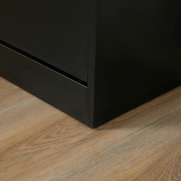 Black shoe cabinet base on wooden floor, showing bottom corner and sturdy feet