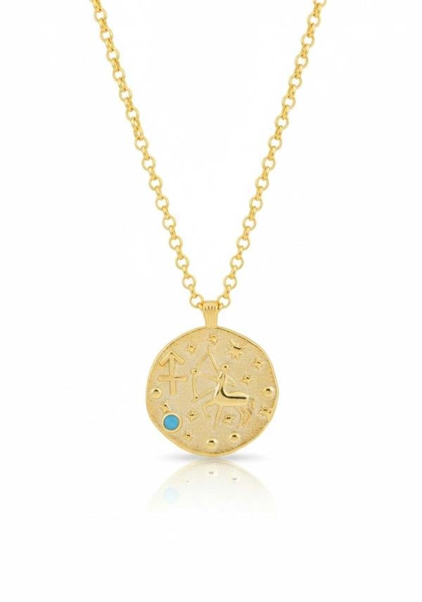 Gold necklace with a round pendant featuring astrological symbols on a white background