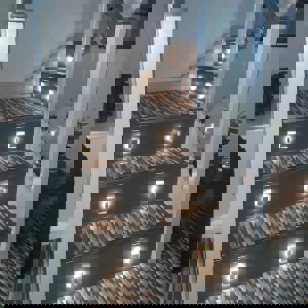 mini interior step light installed on a carpeted stairway