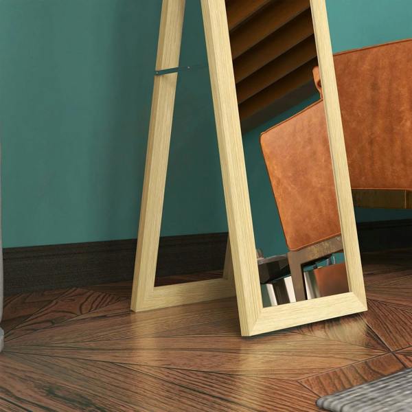Full-length mirror frame and base detail in light natural wood, on floor