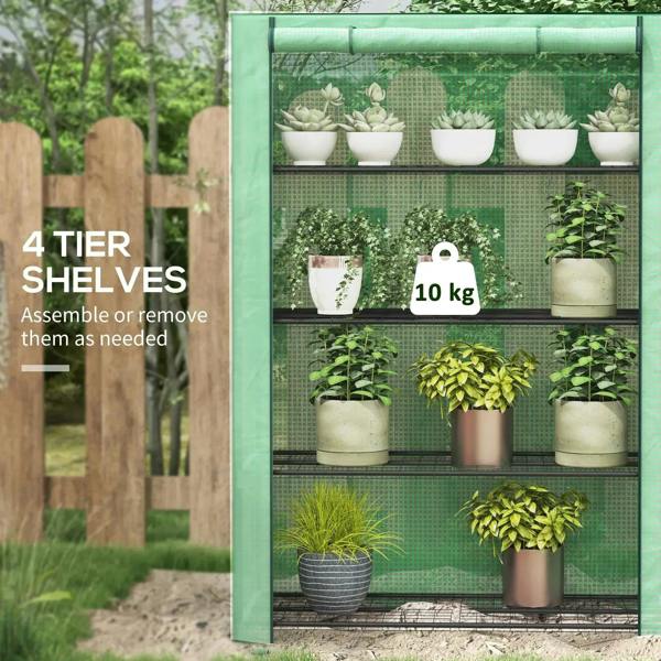 Green mini greenhouse with roll-up door and four wire shelves, holding potted plants