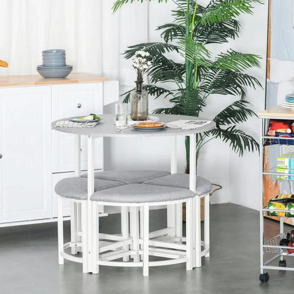 Grey round dining table with two grey upholstered stools beside a white cabinet