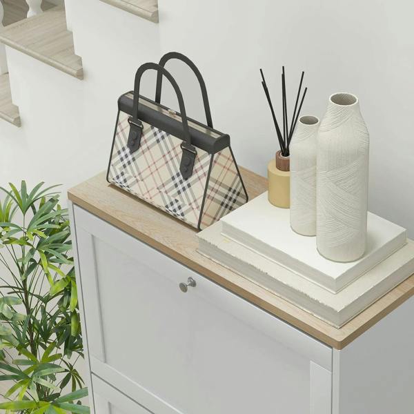 White shoe cabinet with light wood top and drawer fronts, styled with decor