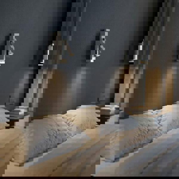 white wal mounted reading light mounted over a bed in a modern bedroom 