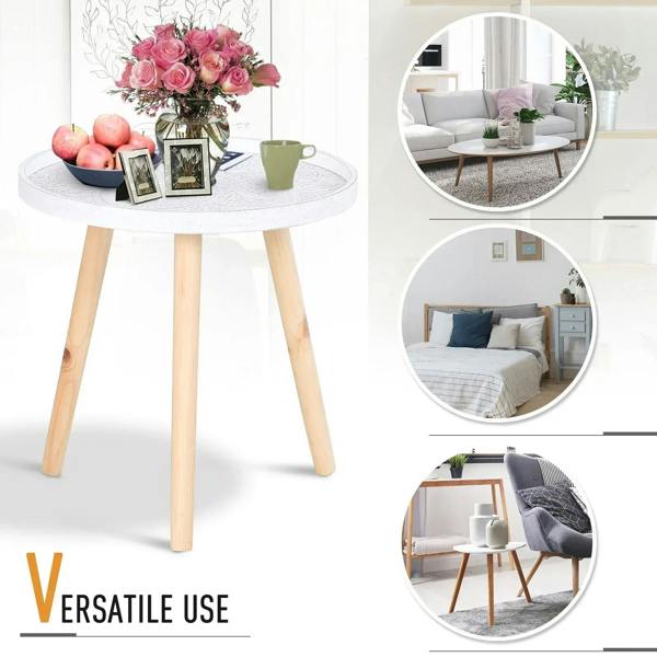 Round white side table with carved tray top, holding fruit, flowers, and a coffee cup