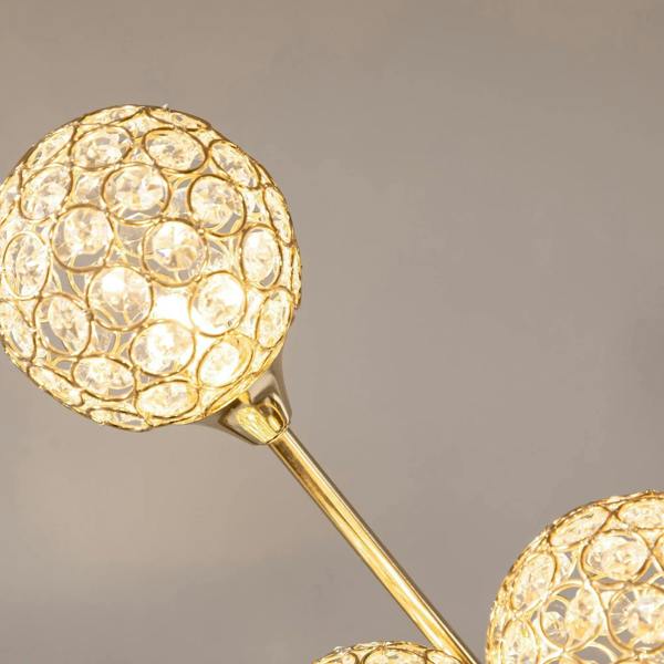Close-up of gold-toned crystal lamp shade with faceted circular details on stem