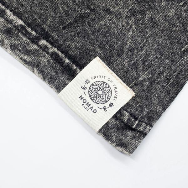 Charcoal stonewashed cotton T-shirt hem with stitched Nomad Sari fabric label