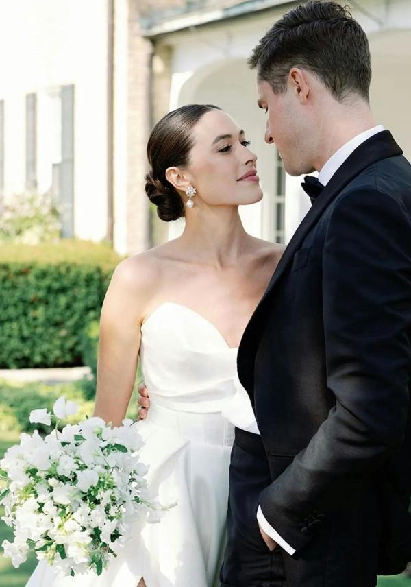 The earring worn by a bride posing with the groom.