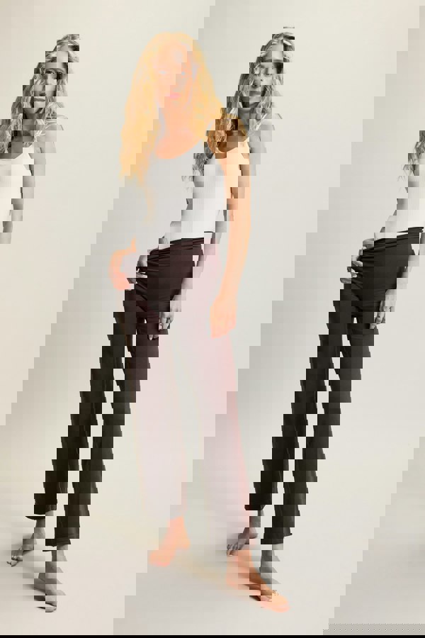 Cream textured bamboo cross-back bodysuit in soft brown fabric, designed for activewear and athleisure. Featuring breathable, moisture-wicking bamboo material that offers stretch and comfort for yoga, Pilates, or everyday layering. The cross-back detailing adds a stylish touch, making it perfect for transitioning from workouts to casual wear.