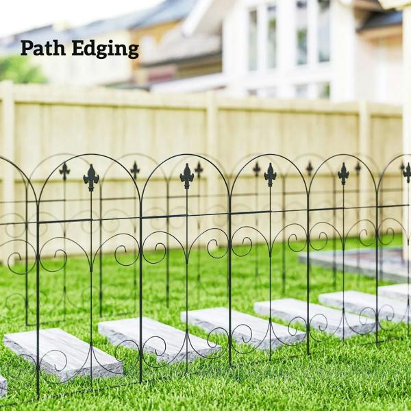 Black metal path edging fence with arched tops and curled scrolls along grass