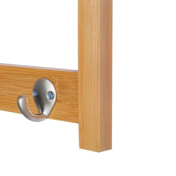 Close-up of two metal hooks on a natural wood wall coat rack rail.