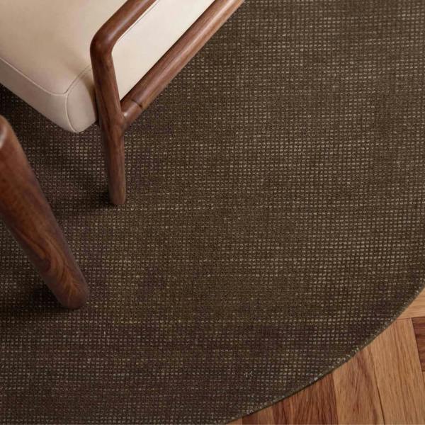 Brown textured rug with a chair and wooden legs in the foreground
