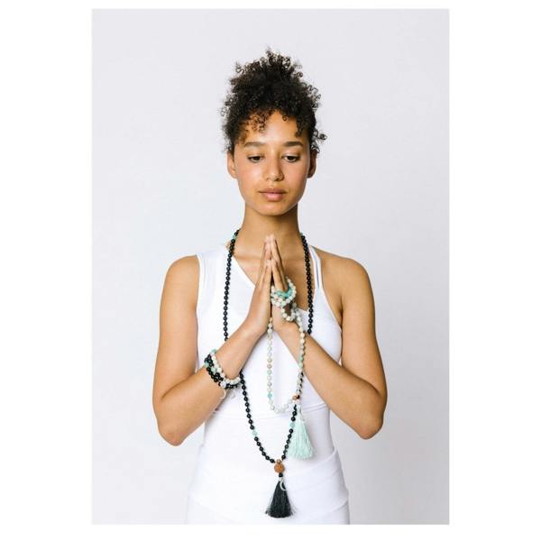 Kati Kaia Black Obsidian Crystal Necklace in black with tassel, worn by a woman in a yoga pose