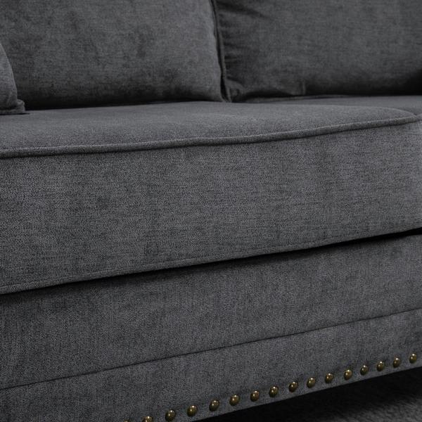 Grey upholstered sofa base with nailhead trim along the bottom edge