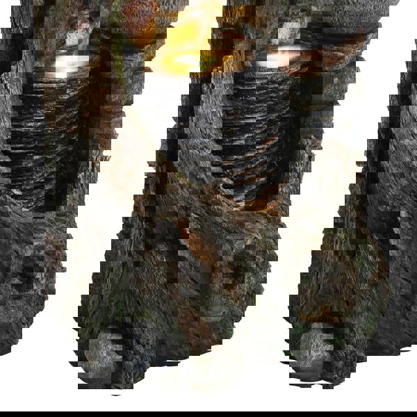 Rustic electric water feature with a textured stone and wood design, cascading water over stacked rocks and illuminated base