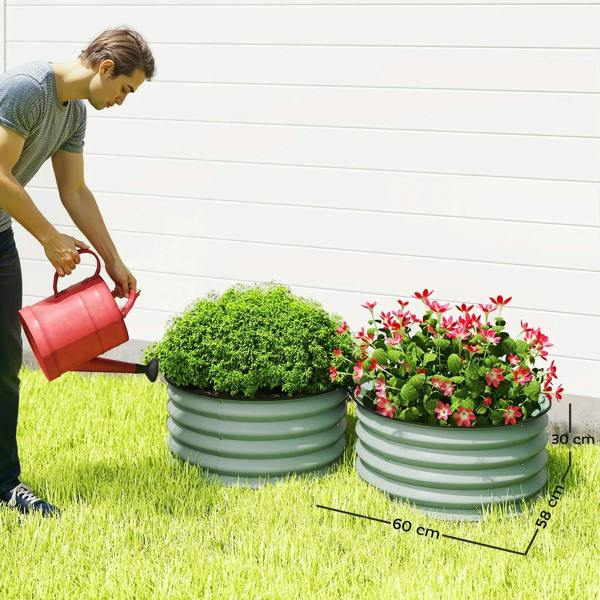 Two green ribbed metal planter boxes in a grass garden bed