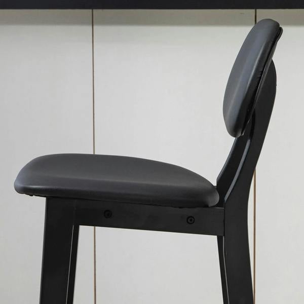 Black bar stool featuring a thick padded backrest and cushioned faux-leather seat