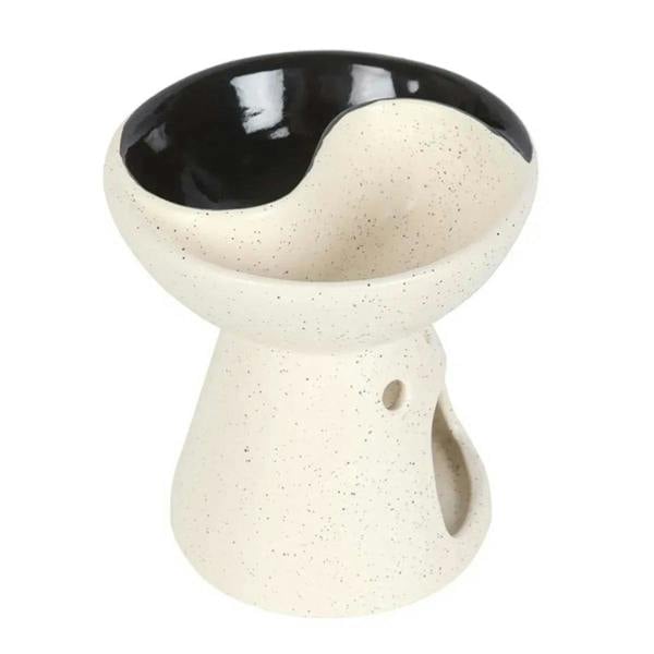 Ceramic yin-yang oil burner with speckled white finish and black glazed bowl; tealight flame