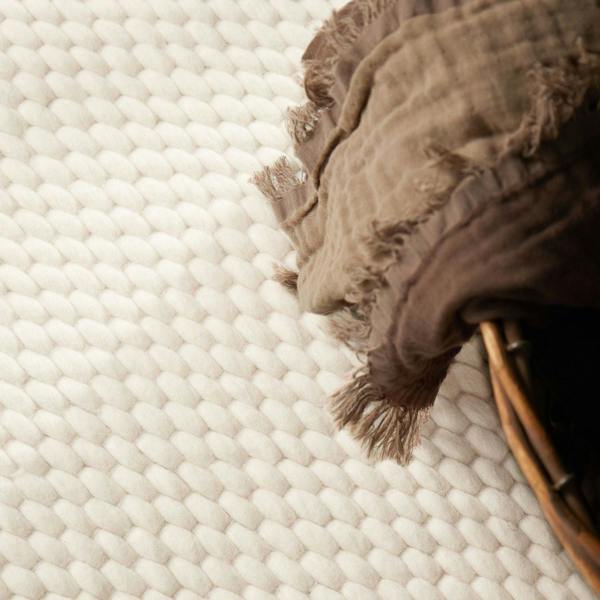 Brown textured rug on a white woven surface
