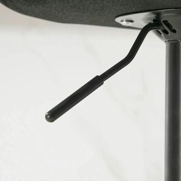 Black metal footrest support bar from a green retro bar stool