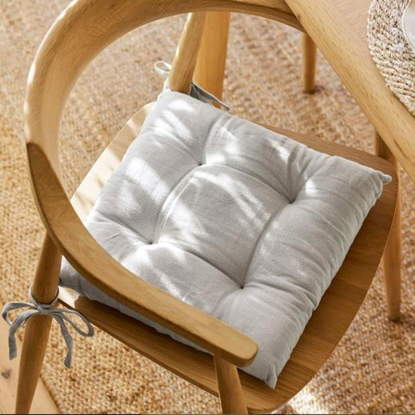 A Flint grey 100% linen seat pad tied to a light oak dining chair.