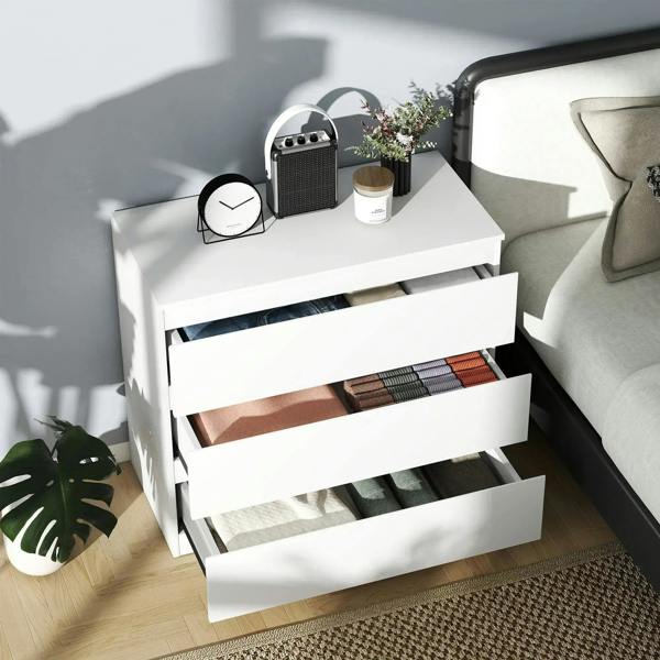 White chest with three drawers pulled out, showing open interior storage.