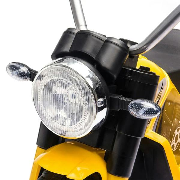 Close-up of yellow 3-wheel kids electric motorbike LED headlight with two small lights