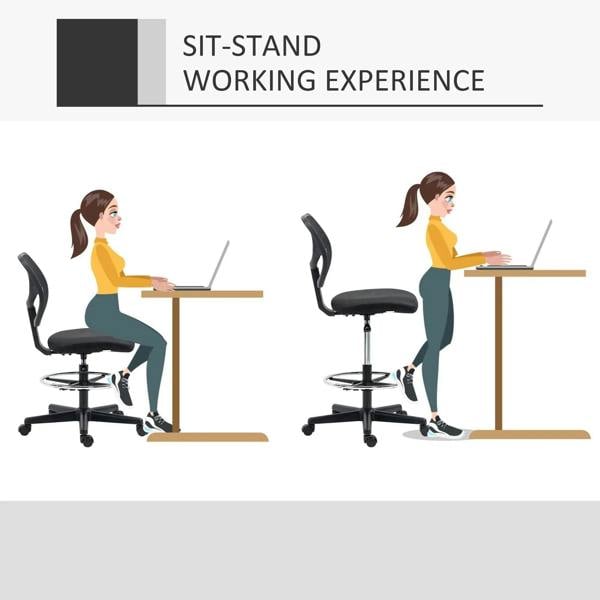 Armless black standing desk chair with mesh back and padded seat, shown at a sit-stand desk