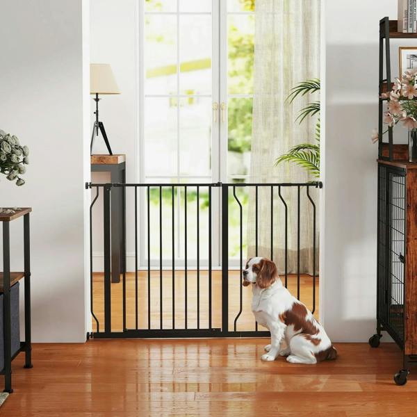 Black pet safety gate installed at a doorway with a dog sitting in front