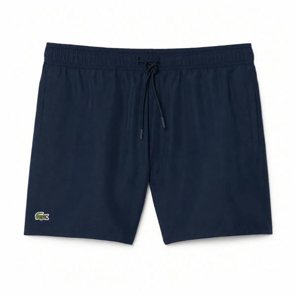 Lacoste navy blue quick-dry swim shorts with drawstring waist and green crocodile logo.