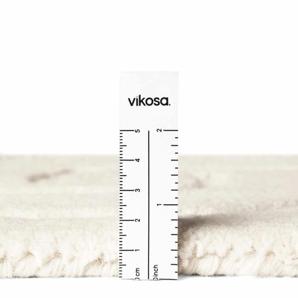 Close-up of a white marble surface with a ruler and 'vikosa' branding.