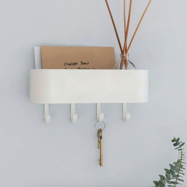 Lily white powder-coated key hook shelf mounted on a pale grey wall holding keys, mail, and diffusers