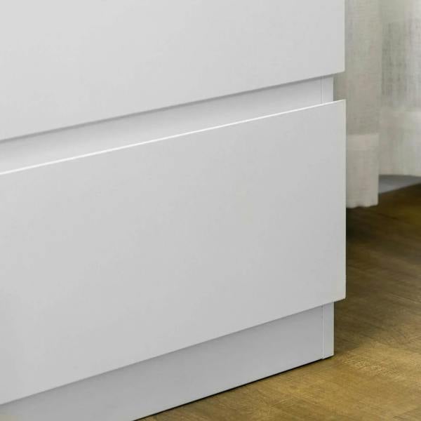 Close-up of white drawer fronts and side panel on a three-drawer chest.